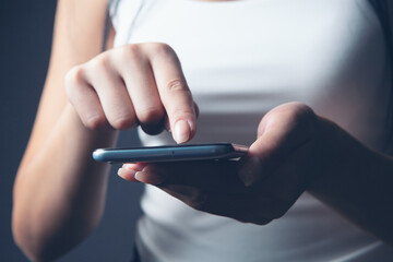 a young girl stands with a phone