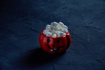 Poster - Jack-o-lantern shaped mug with mini marshmallows on a black background - Halloween backdrop