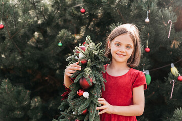 Wall Mural - Merry Christmas. Portrait of happy funny child girls in Santa hat with Christmas wreath.