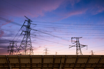 Wall Mural - Transmission towers and solar panels are clean energy concepts. Sunset background