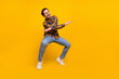 © deagreez - Full body photo of lovely brunet young guy dance wear shirt jeans sneakers isolated on yellow background