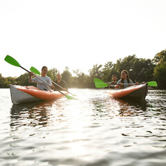 Wall Mural - Relaxed young friends kayaking together on a river, spending weekend outdoors on a summer day