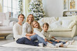© Inna Vlasova - Happy family in white sweaters sitting on the living room floor