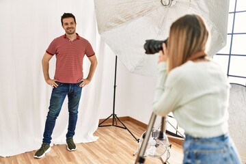 Sticker - Handsome model posing for professional photographer woman at photography studio.