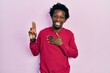 © Krakenimages.com - Young african american man wearing casual clothes smiling swearing with hand on chest and fingers up, making a loyalty promise oath