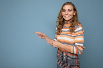 Wall Mural - Photo of cute nice winsome positive adult woman wearing casual outfit isolated on background wall with copy space pointing at free space with hands