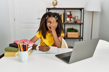 Sticker - Young african american girl doing homework at home yawning tired covering half face, eye and mouth with hand. face hurts in pain.