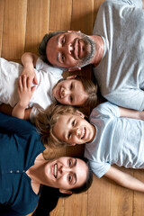 Wall Mural - Portrait of smiling parents with kids lying on floor