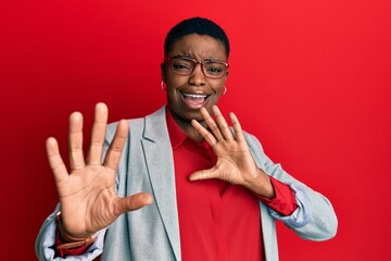 Sticker - Young african american woman wearing business jacket and glasses afraid and terrified with fear expression stop gesture with hands, shouting in shock. panic concept.