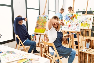 Poster - Group of middle age artist at art studio smiling cheerful playing peek a boo with hands showing face. surprised and exited