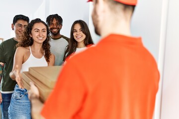 Wall Mural - Group of people holding take away pizzas from deliveryman at home.