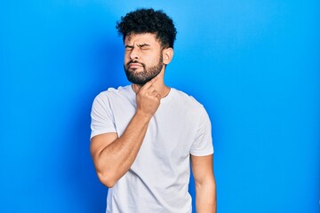 Canvas Print - Young arab man with beard wearing casual white t shirt touching painful neck, sore throat for flu, clod and infection