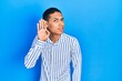 © Krakenimages.com - Young african american guy wearing casual clothes smiling with hand over ear listening an hearing to rumor or gossip. deafness concept.