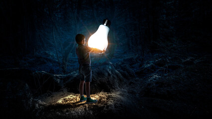 Wall Mural - Boy with a glowing light bulb . Mixed media