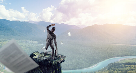 Wall Mural - young businessman standing and rock mountain . mixed media