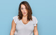 Young plus size woman wearing casual white t shirt in shock face, looking skeptical and sarcastic, surprised with open mouth
