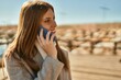 © Krakenimages.com - Young redhead girl smiling happy talking on the smartphone at the beach.
