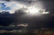 Sun breaking through clouds . Dark clouds with sun rays . Sky before hurricane