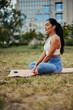 Young asian woman practicing yoga outdoors in park