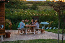 Cheerful Family Enjoying A Family Dinner Outside At Home During Evening