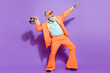 © deagreez - Full length photo of old positive happy man hold disco ball point look empty space isolated on purple color background