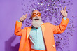 Photo of cheerful joyful cool old man confetti fall wear sunglass clubber isolated on purple color background