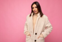 Caucasian Photo Of Attractive Self-confident Stylish Young Brunette Woman Wearing Autumn Beaige Warm Coat Isolated On Pink Background With Empty Space. Fashion Concept