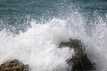 Waves Crash Onto A Giant Boulder And Leave A Foamy Splash On The California Rugged Coast