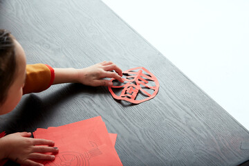 Asian little girl preparing calligraphy, painting and paper cutting for Chinese New Year