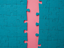 A Gap, A Crack In The Puzzle Block. The Gap In The Team, The Division Of A Large Group Into Two, The Concept. Two Blocks Of Assembled Puzzles Are Open With An Offset, Blue On Pink.
