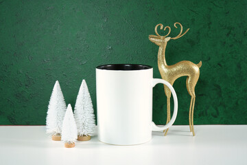 Coffee mug product mockup. Christmas svg craft product mockup with gold reindeer and white Xmas trees against a textured green background.