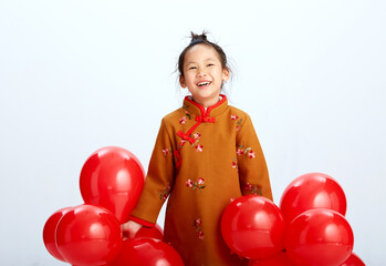 Wall Mural - Cute Asian little girl playing with red festive balloons indoors on white background