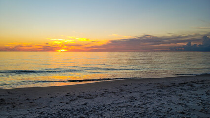 Fototapete - Sun setting in southwest Florida in Naples Beach. Big sky over horizon