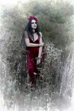Fototapeta Przestrzenne - A woman in a wreath of red flowers in makeup for Halloween