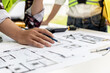 © kamiphotos - Two architect-engineers are consulting to modify the blueprints of the contracted house, they have a meeting to inspect the house designs before meeting with the client. Home design ideas.