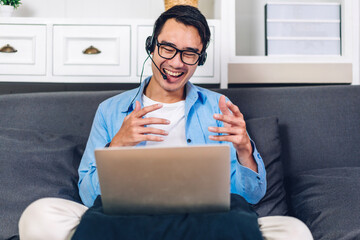 Wall Mural - Young creative smiling happy asian man relaxing using desktop computer working and video conference meeting online chat at home.work from home concept