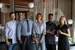 © fizkes - Portrait of happy successful diverse business team. Multiethnic employees of different ages, races smiling at camera in office. Training group with mature Black teacher, young female mentor