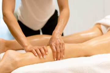 Wall Mural - Beauty salon professional pouring oil from a massage candle on the back of his patient.