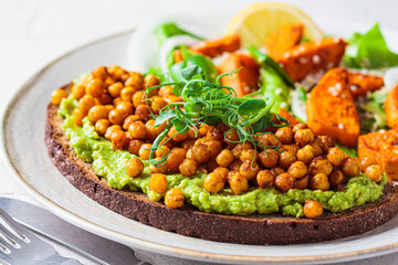 Wall Mural - Toast with guacamole and crispy chickpeas, close-up.