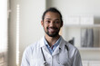 © fizkes - Head shot portrait of happy young African American doctor, physician, therapist. Mixed race general practitioner in white coat with stethoscope posing in hospital office, looking at camera, smiling