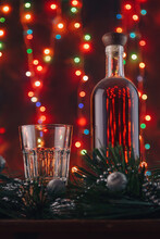 Vintage Dusty Alcohol Drink Bottle, Whiskey, Brandy, Scotch, Rum Glass, Pine Branches, Silver Toys, Garland Lights Bokeh Backdrop. Merry Christmas, Vertical