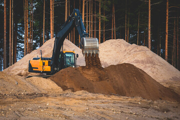 Wall Mural - Yellow heavy excavator and bulldozer excavating sand and working during road works, unloading sand during construction of the new road