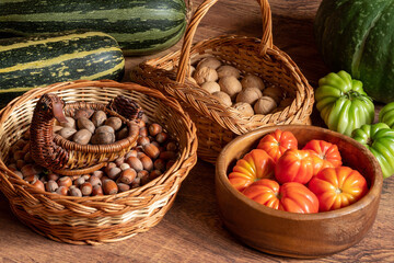 Wall Mural - harvest of fresh tomatoes, pumpkin and courgettes and baskets with hazelnuts and walnuts stacked on the floor