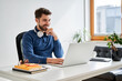 © baranq - Male student learning on laptop at home sitting at desk