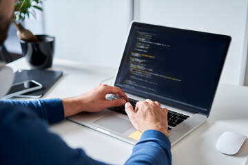 Closeup of computer programming typing on laptop