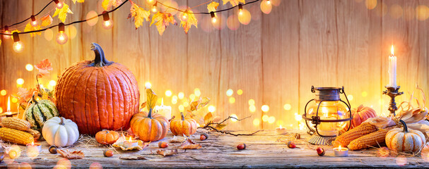 Wall Mural - pumpkins on wooden table - thanksgiving background with vegetables and bokeh lights