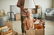 Portrait of two cheerful boys playing in big cardboard box while family moving to new house, copy space