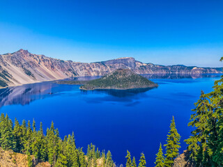 Wall Mural - blue lake in the mountains with large volcanic cinder cone island.