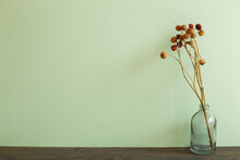Vase Of Dry Flowers On Wooden Table. Green Wall Background
