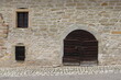 einfaches Tor aus Holz und kleine Fenster in alter Mauer aus Bruchstein Altstadt Stadtmauer Burgmauer Scheune Scheunentor